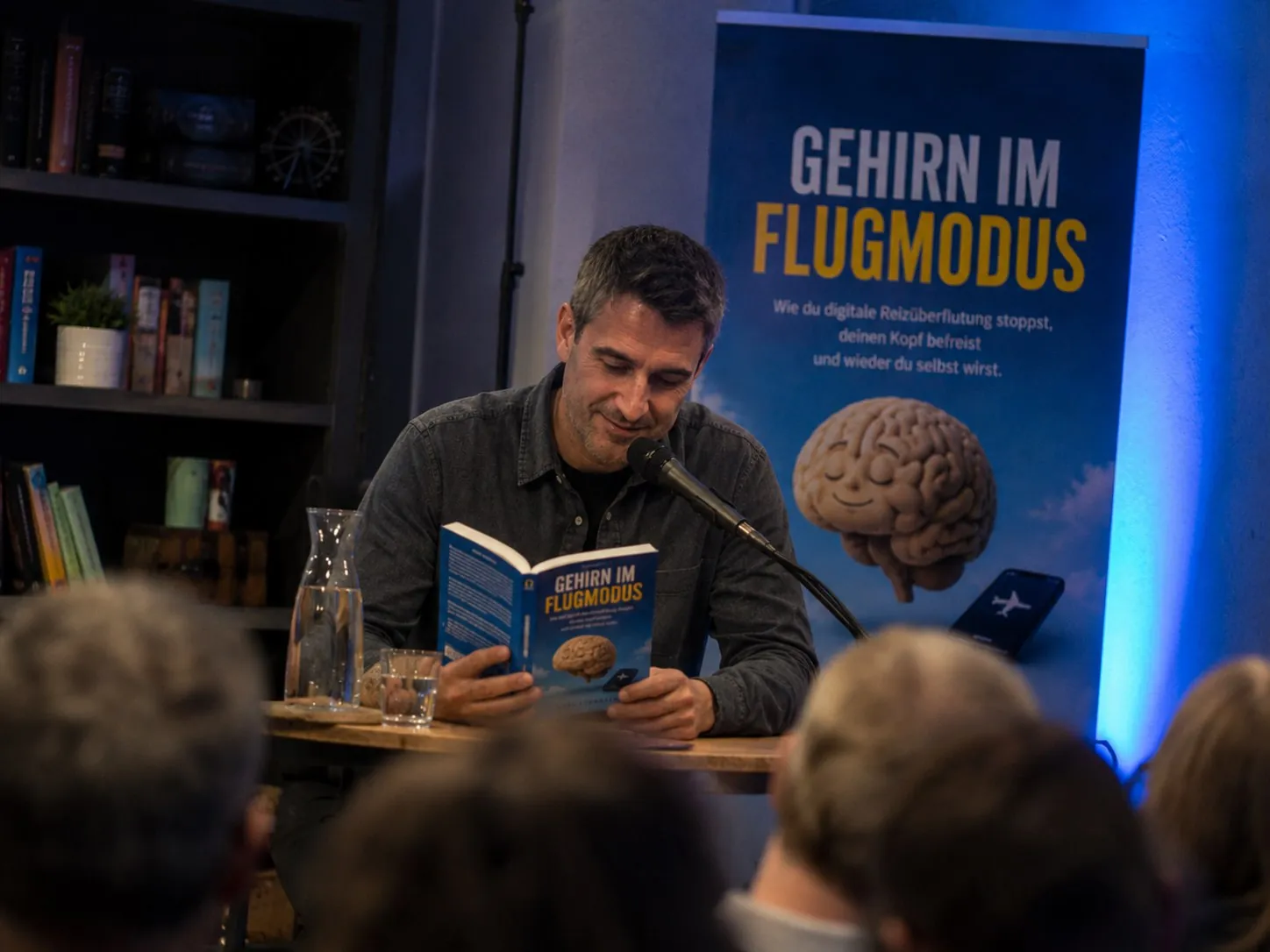Lars Konarek liest vor Publikum aus seinem Buch Gehirn im Flugmodus